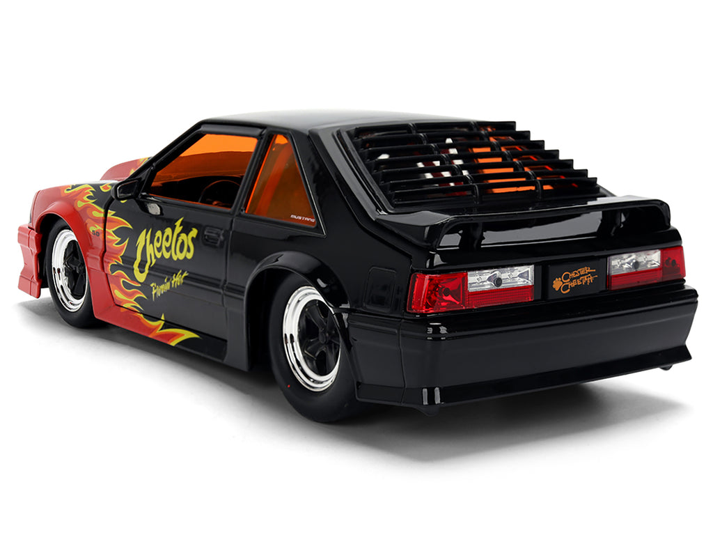 1989 Ford Mustang GT Black with Red Flame Graphics and Chester Cheetah Diecast Figure 'Cheetos Flamin' Hot' 'Hollywood Rides' Series 1/24 Diecast Model Car by Jada
